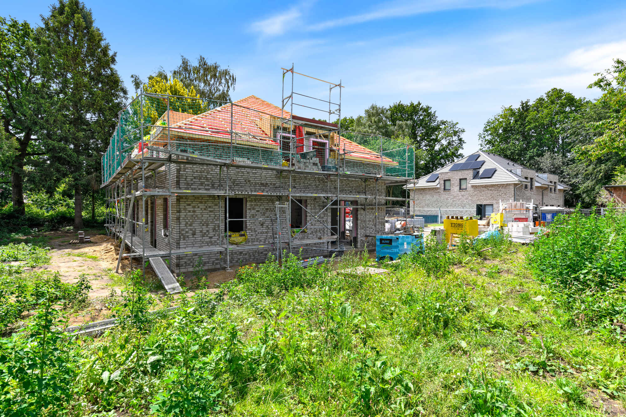 Baufortschritt: Seitenansicht mit Dachstuhl und Klinkerfassade